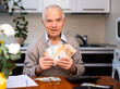 © caftor - Elderly happy smiling pensioner with money in hands
