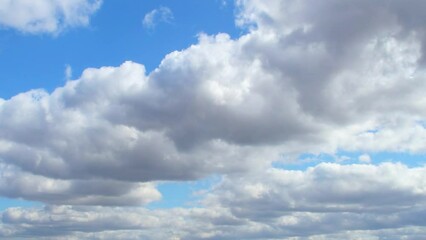 Wall Mural - Huge, low clouds slowly move across the sky. Cumulus white clouds with dark bottoms.