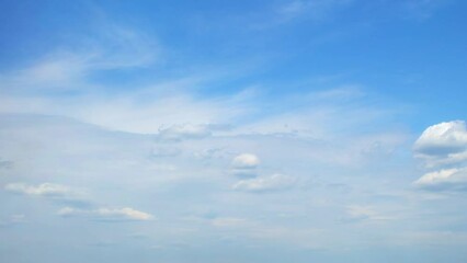 Wall Mural - Slowly moving white flat clouds cover the sky. Blue sky with several layers of clouds.