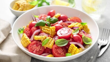 Canvas Print - Tomato and corn salad with fresh basil, onion, dressed with olive oil. Mexican food, tomato corn salad Esquites. Fresh vegetable's salad bowl, close-up, stock video 4k