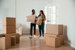 © standret - Walking in, holding boxes. African American couple are moving into new house