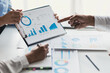 © Wasan - Business consulting meeting is discussing business plan analysis with financial data and business growth charts to plan strategies for generating company profits.
