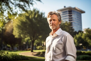 Sticker - Portrait of a merry man in his 50s wearing a classic white shirt isolated in vibrant city park