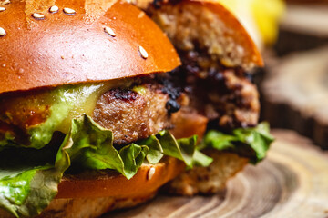 side view cheeseburger grilled beef patty with cheese and lettuce between burger buns