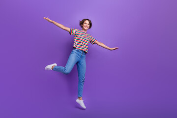 Sticker - Full length photo of cheerful carefree girl wear trendy clothes open hands flying air empty space isolated on violet color background