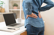 © Pormezz - Close-up woman massaging her lower back has back pain because of sitting posture during work in office.