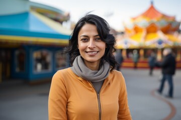 Sticker - Portrait of a content indian woman in her 40s sporting a long-sleeved thermal undershirt in vibrant amusement park