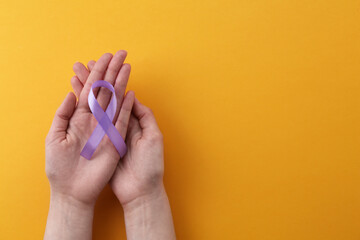 Wall Mural - Woman with violet awareness ribbon on orange background, top view. Space for text