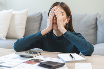 Wall Mural - Financial owe asian woman sitting cover face with hands, stressed by calculate expense at home, looking at invoice or bill, have no money to pay, mortgage or loan. Debt, bankruptcy or bankrupt concept