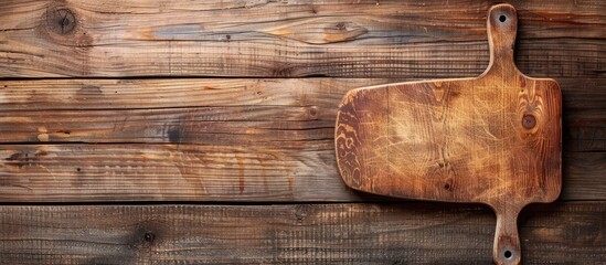 Poster - Top view of a kitchen cutting board on a wooden background, with copy space image.