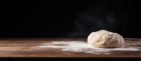 Sticker - Dough lump resting on a wooden table with a dark backdrop, showing ample copy space image.