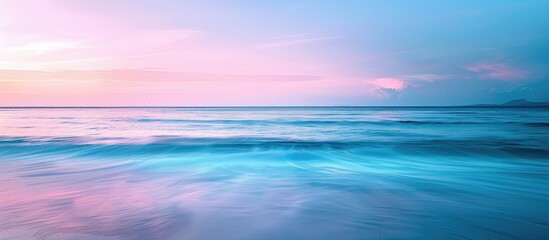 Poster - Seascape with a serene beach at sunset. The horizon filled with a blend of blue and pink hues, creating a tranquil setting for the copy space image.