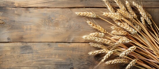Poster - A top-down view of wheat ears displayed on a wooden background with a clear area for text, suitable for a copy space image.
