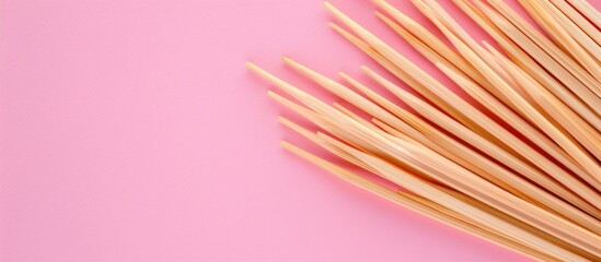 Poster - Toothpicks made of wood placed on a pink backdrop with copy space image.