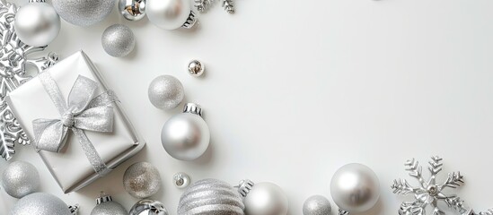 Poster - Top view of silver Christmas decoration balls and a gift on a white background with a festive Xmas pattern, providing room for text in the copy space image.