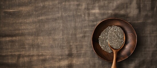 Poster - Flat lay featuring a wooden bowl filled with chia seeds on a textured burlap backdrop. A spoon is placed on top, emphasizing the copy space image layout.