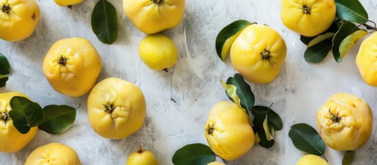 Poster - A beautifully arranged display of organic quinces with leaves on a bright table in a flat lay style, offering ample copy space image.
