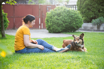 Wall Mural - Woman playing with her dog outdoors