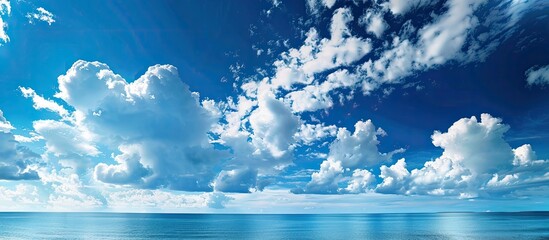 Wall Mural - The tranquil coastal scene shows a clear blue sky with clouds, offering a peaceful ambiance ideal for a copy space image.