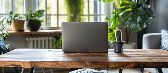 Leinwandbilder - Modern home office setup with a gray laptop on a wooden table, a perfect workplace for staying and working at home, showcasing a sleek interior design with a convenient copy space image.