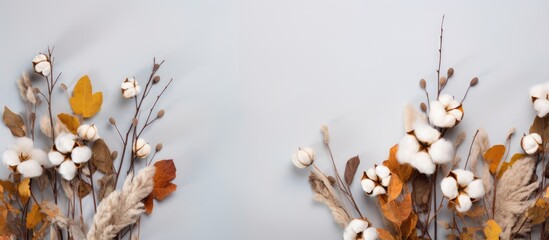 Wall Mural - Autumn-themed arrangement with eucalyptus branches, cotton flowers, and dried leaves on a soft gray backdrop. Represents the autumn season with a flat lay and top-view perspective, featuring a copy