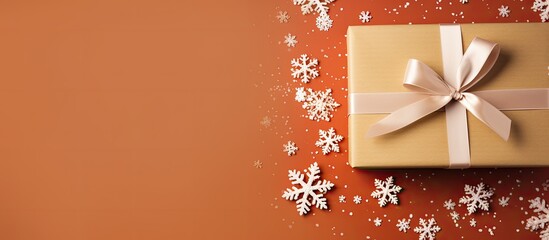 Poster - Christmas gift box on vibrant paper with ribbon, ornaments, and snowflake, perfect for the holidays. Top view flat lay with a festive copy space image.