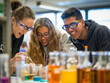 © JMDuran Photography - High school students surrounded by bottles with different colored liquids doing experiments together at a table in the school laboratory. Selective focus.