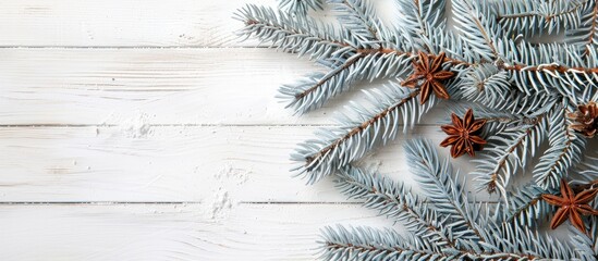 Poster - A festive setting with a blue fir tree branch, wooden cut, cinnamon sticks on a white wooden backdrop for a Christmas card, with space for custom text or images.