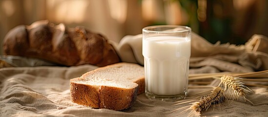 Poster - A slice of bread and a glass of milk placed on a cloth-covered table with ample copy space image.