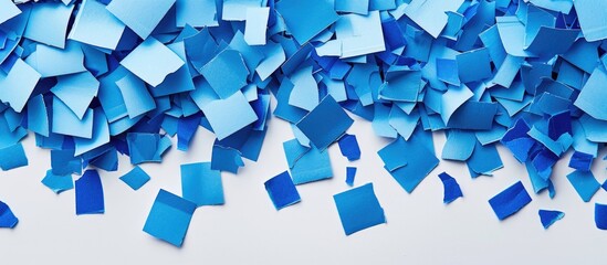 Aufkleber - Blue paper pieces on a white background with copy space image.