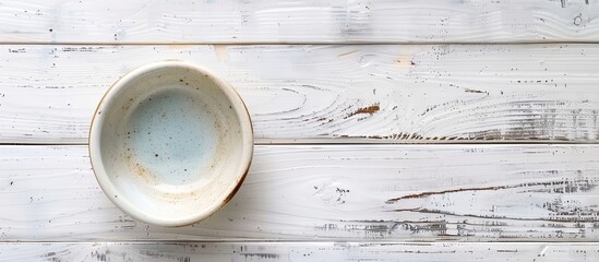 Poster - Top-down view of an empty ceramic bowl on a white wooden table, with room for adding text or a copy space image included.