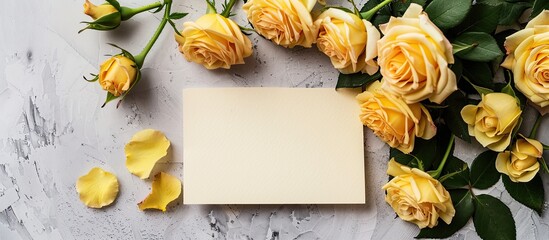 Poster - Yellow roses adorning a blank card set against a light grey background in a flat lay composition with copy space image.
