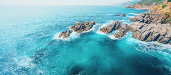 Aufkleber - Scenic aerial shot of a serene blue ocean with rocky coastline, set against a stunning backdrop of natural beauty, suitable for a copy space image.