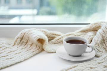 Wall Mural - Beige knitted scarf and tea on windowsill