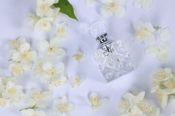 Wall Mural - Aromatic perfume in bottle and beautiful jasmine flowers on white background, flat lay