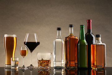 Canvas Print - Bottles and glasses with different alcoholic drinks on table against beige background