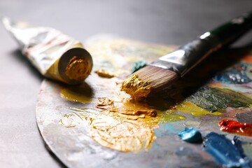 Canvas Print - Artist's palette, brush and paints on grey table, closeup