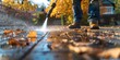© AminaDesign - A man is using a pressure washer to clean a sidewalk covered in autumn leaves, tidying up the garden outdoor space