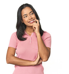 Wall Mural - simple portrait of a young latina relaxed thinking about something looking at a copy space.