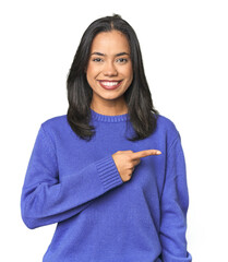 Wall Mural - simple portrait of a young latina smiling and pointing aside, showing something at blank space.