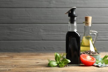 Wall Mural - Bottle of balsamic vinegar, oil and other products on wooden table, space for text