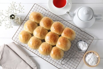 Poster - Delicious dough balls, powdered sugar, tea, teapot and gypsophila flowers on white wooden table, top view