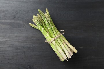 Wall Mural - Bunch of fresh green asparagus stems on gray wooden table, top view