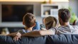 © acnaleksy - Family sitting together on a couch and watching TV