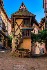 Poster - Ornate traditional half timbered houses with blooming flowers in a popular village on the Alsatian Wine Route in Eguisheim, France