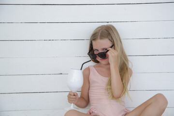 Portrait of adorable little girl enjoying summer vacation in the beach bar