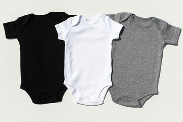 Set of three blank baby bodysuits for mockups - white, grey, black triplets