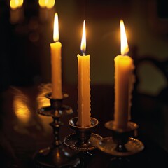 Vintage candles burn in old-fashioned candle holders, casting a warm golden glow against a dark backdrop.