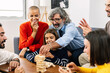 © Xavier Lorenzo - Multigenerational caucasian family having fun playing together at home, sitting together on sofa in living room.