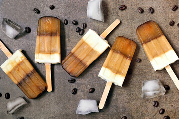 Poster - Group of coffee and cream popsicles. Top down view scattered on a brown background.